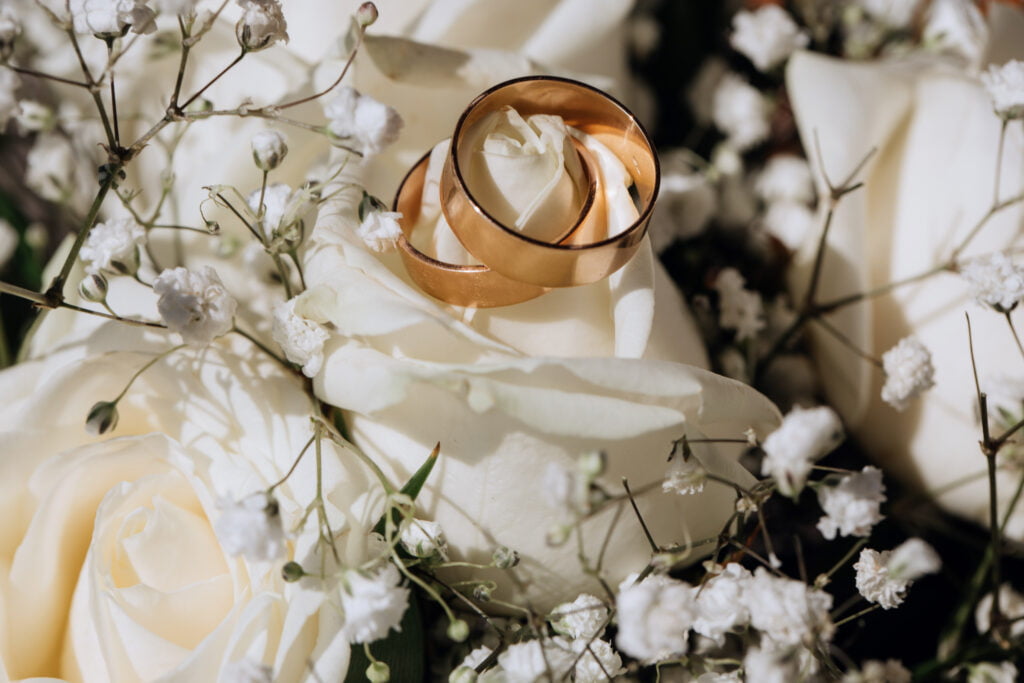 Aliiance de mariage sur un drap blanc avec des fleurs blanches