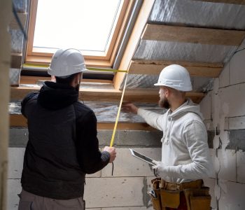 Deux artisans qui changent un velux afin de réaliser une rénovation énergétique d’un logement.