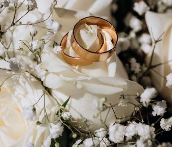 Aliiance de mariage sur un drap blanc avec des fleurs blanches